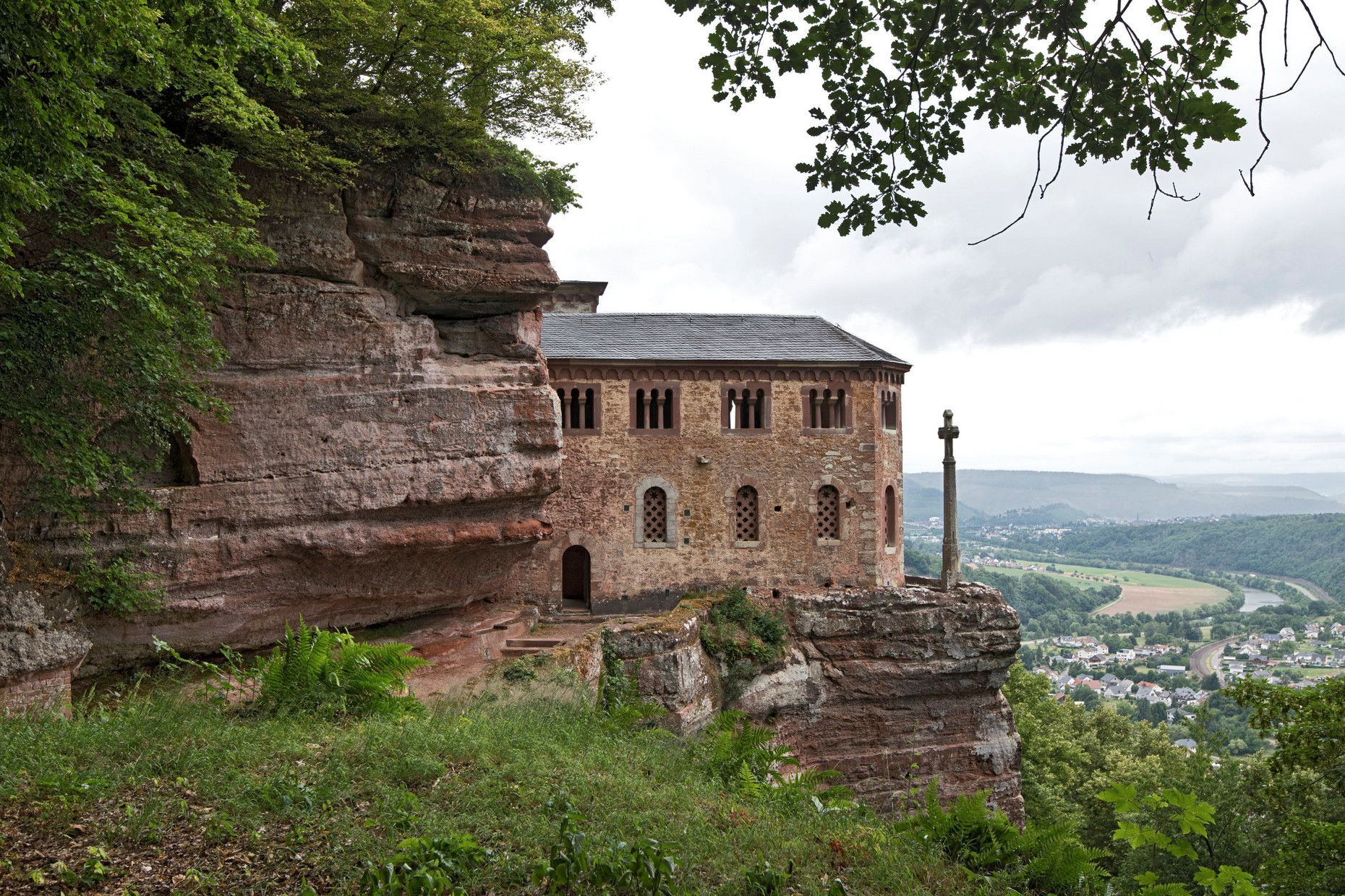 Sandsteinfelsen mit Klause Kastel, Bäume, rechts Blick ins  Tal mit Dorf
